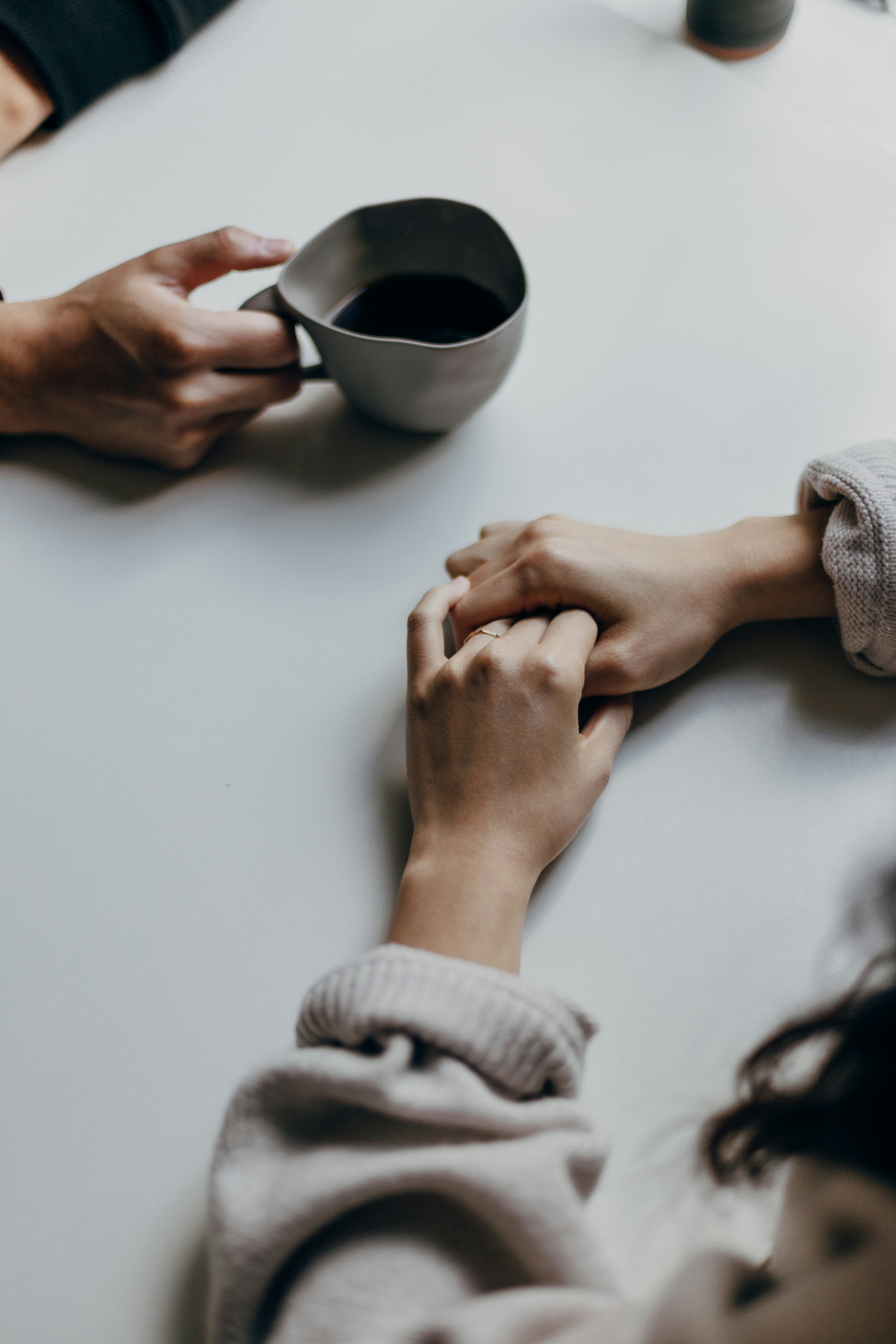 Two people reaching toward each other across a table
